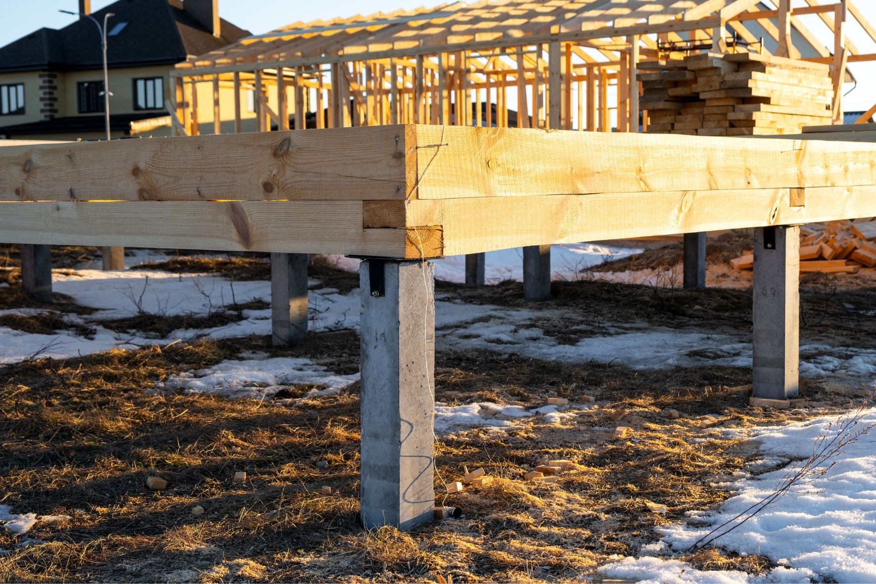 Structure en bois sur pieux avec personne debout sur un chantier en milieu naturel  dans Lanaudière